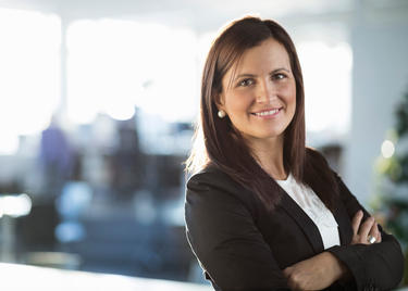 Portrait of confident businesswoman standing arms crossed in office Device Backup: for PC, MAC, Servers & NAS Drives